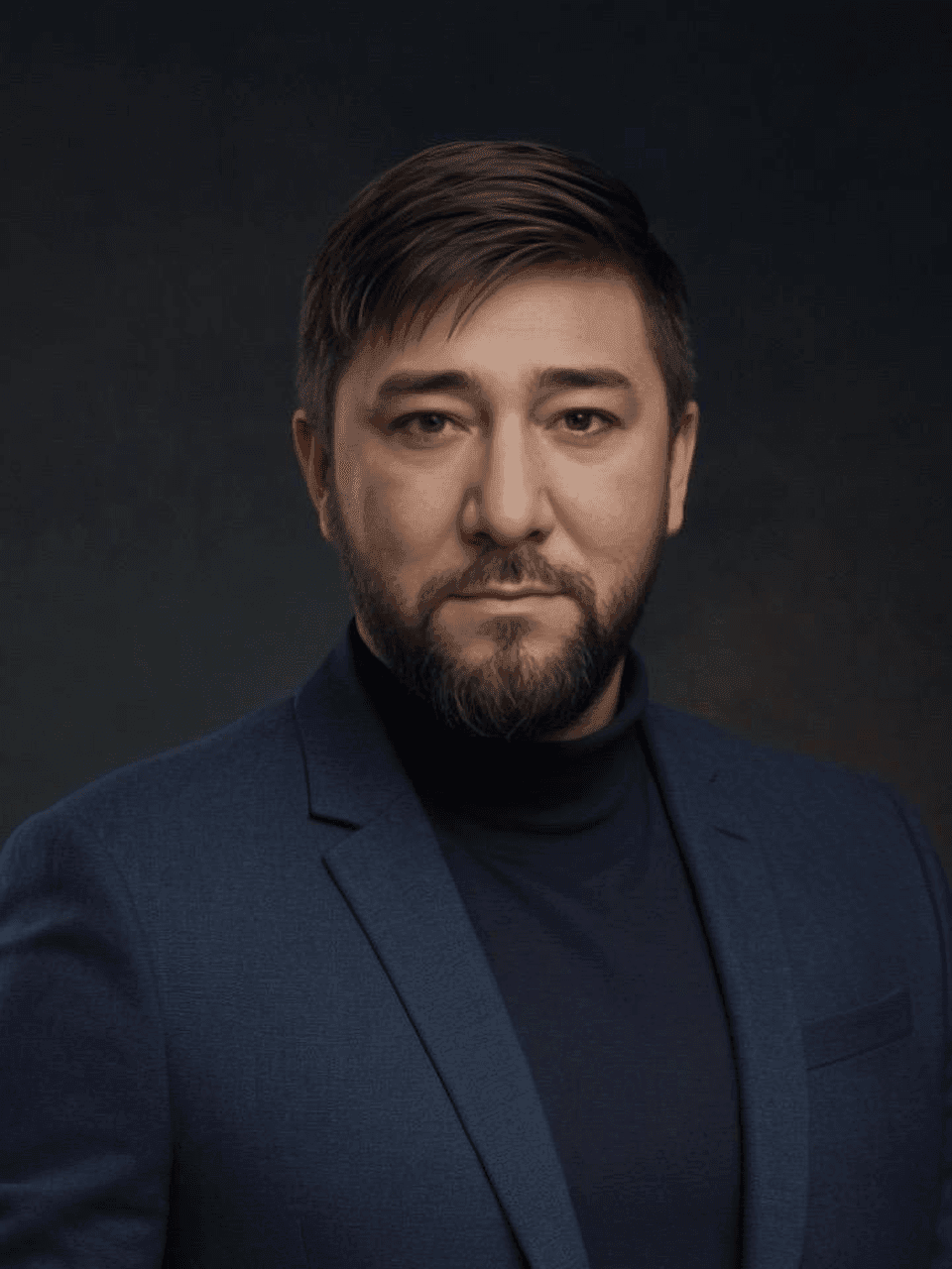 Person wearing a navy blue suit and black turtleneck against a dark background.